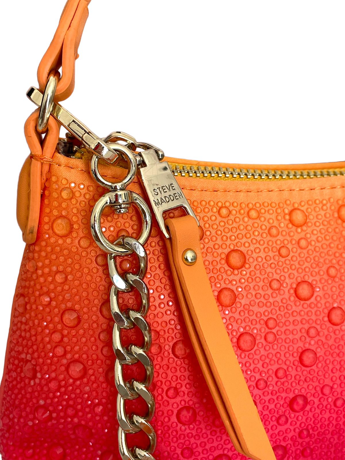 Detalles metálicos y correa ajustable de la bolsa Steve Madden naranja.